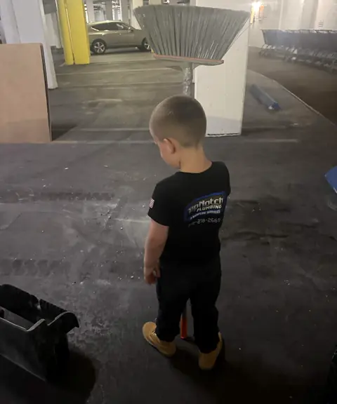 Jaxson in a Top Notch shirt looking over a job site in a parking garage