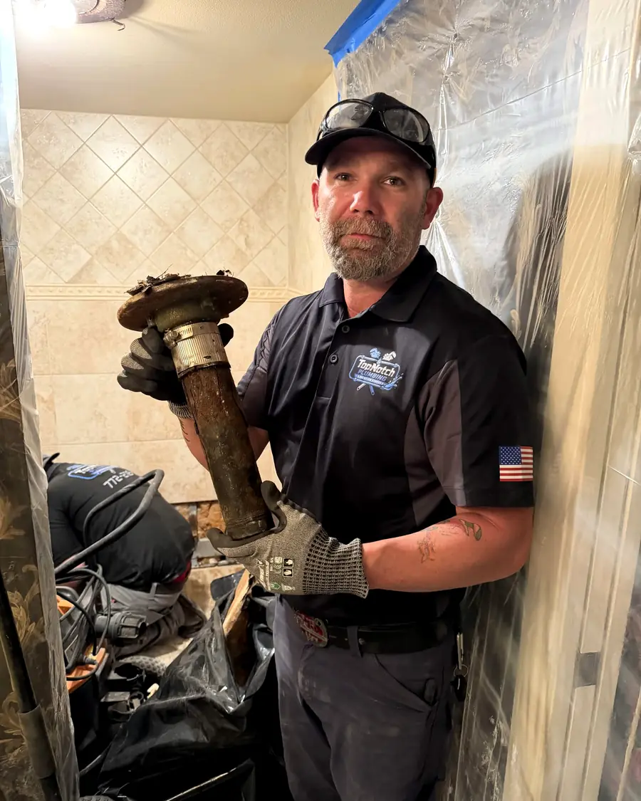 Justin Virginia holding a corroded pipe section he removed during a repair