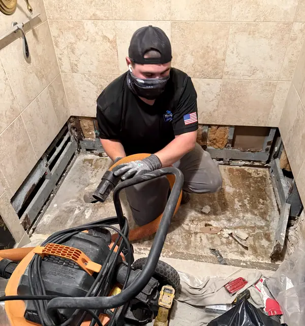 A Top Notch plumber breaking out an old shower pan