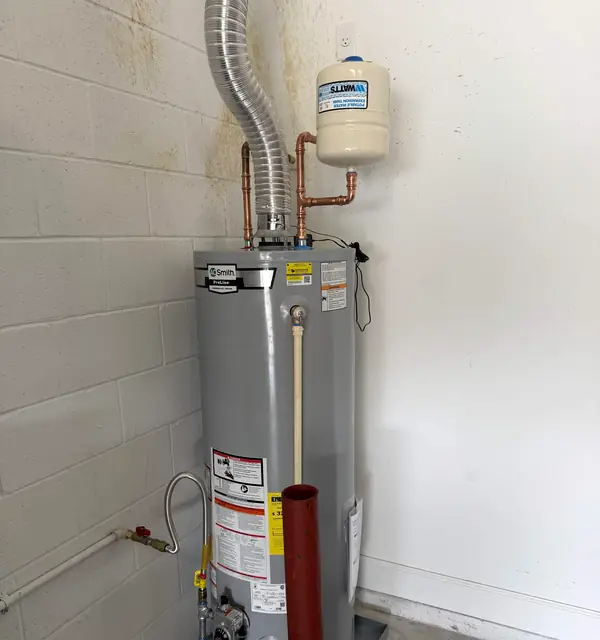 A newly installed gas water heater with copper connections