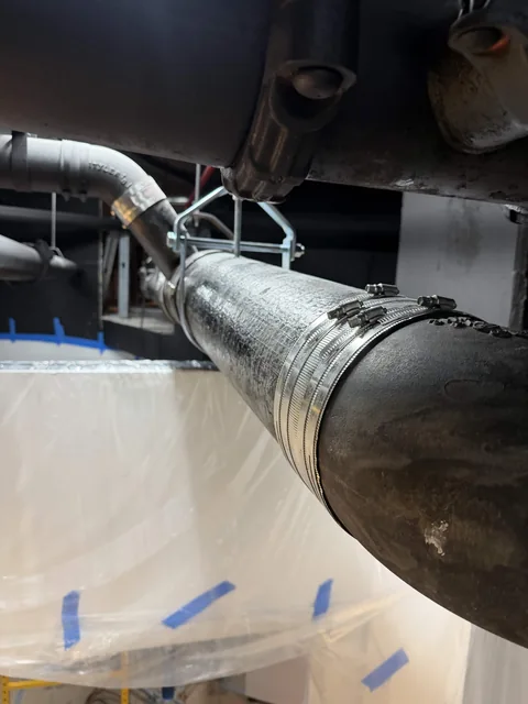 A section of overhead pipe joined to an existing line with banded couplings