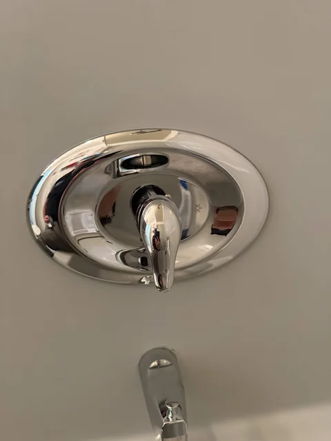 Chrome shower trim and control handle on a finished wall